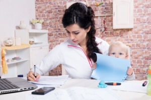Young Woman With Baby Working From Home